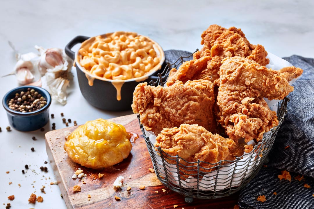 Basket of fried chicken with mac and cheese and a honey butter biscuit